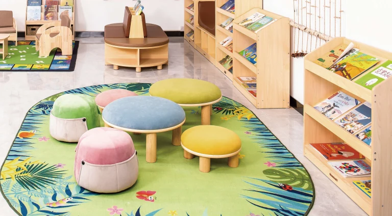 Pufes redondos coloridos, mesa baixa e expositores de livros
